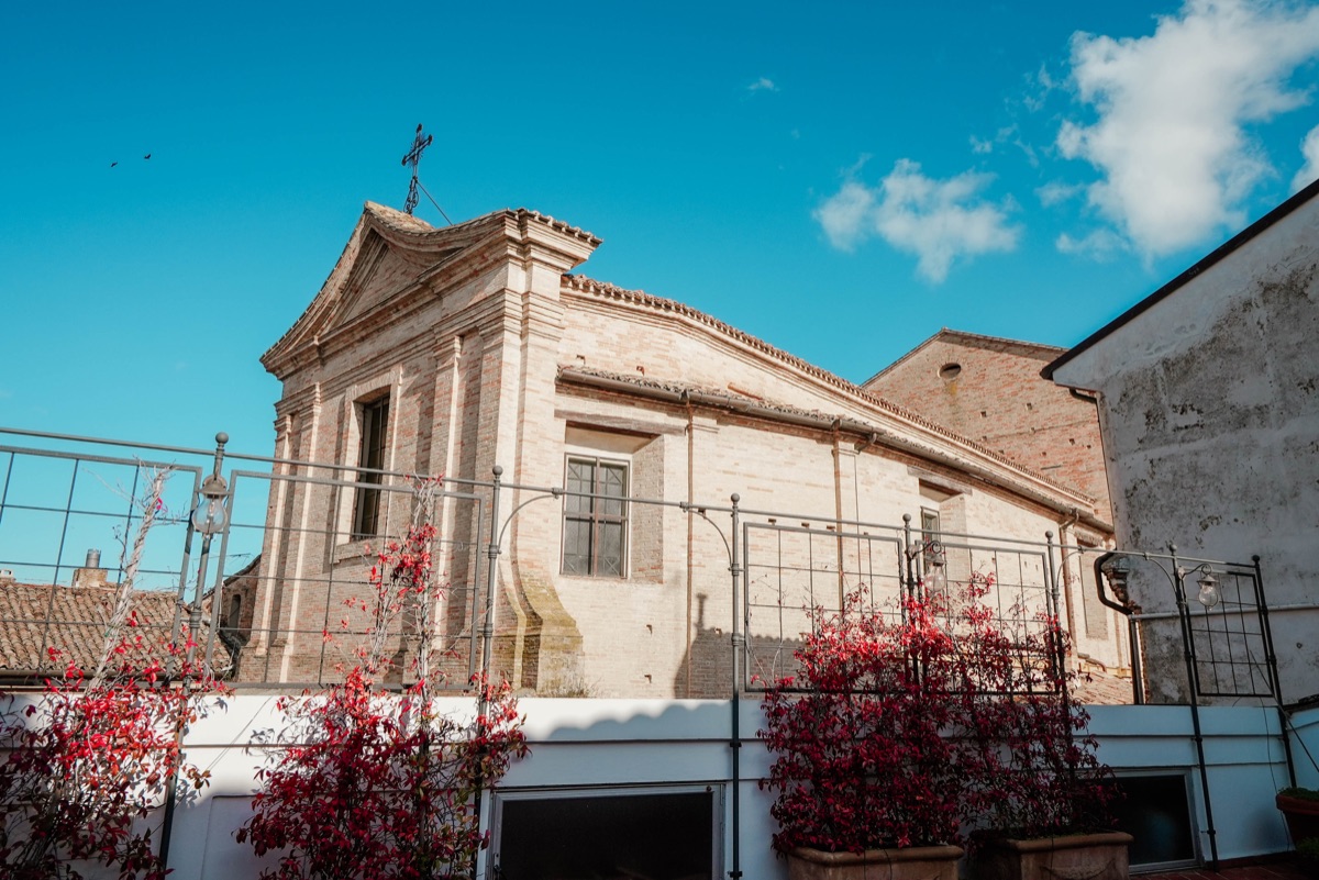 Vista sulla chiesa dalla terrazza tra i rampicanti rossi